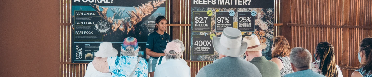 A group attends an educational talk about coral reefs, highlighting community efforts to build climate resilience and protect vital ecosystems.